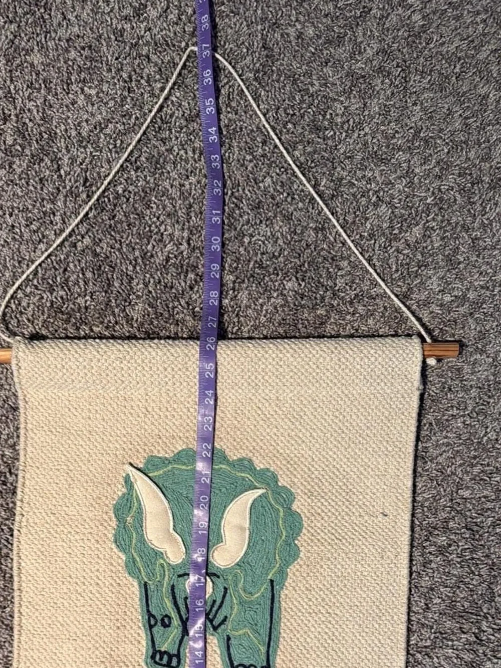 Handwoven Cream Wall Hanging with Green Triceratops Motif Nursery Design